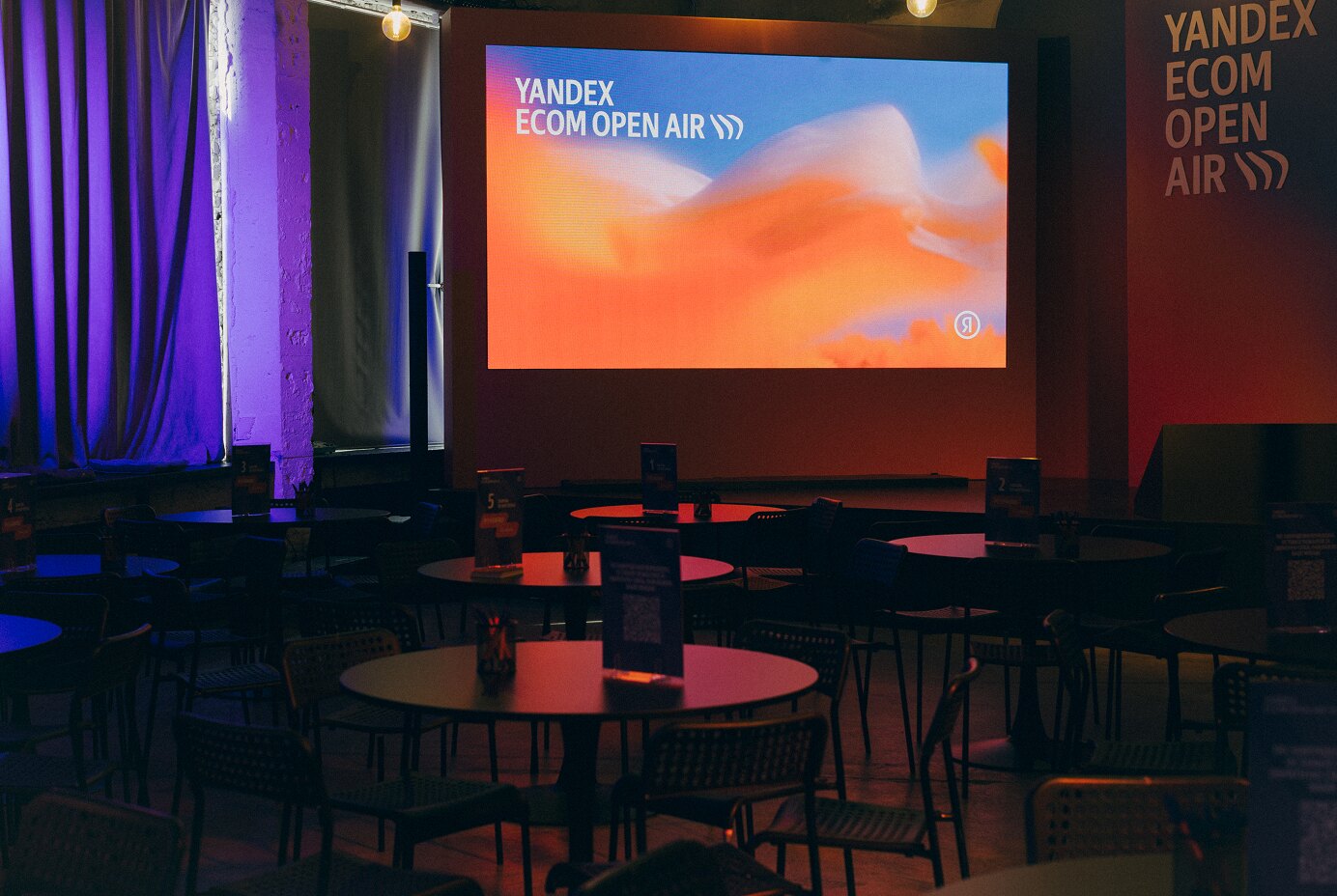 Кафе Yandex Ecom Open Air, на экране — заставка фестиваля